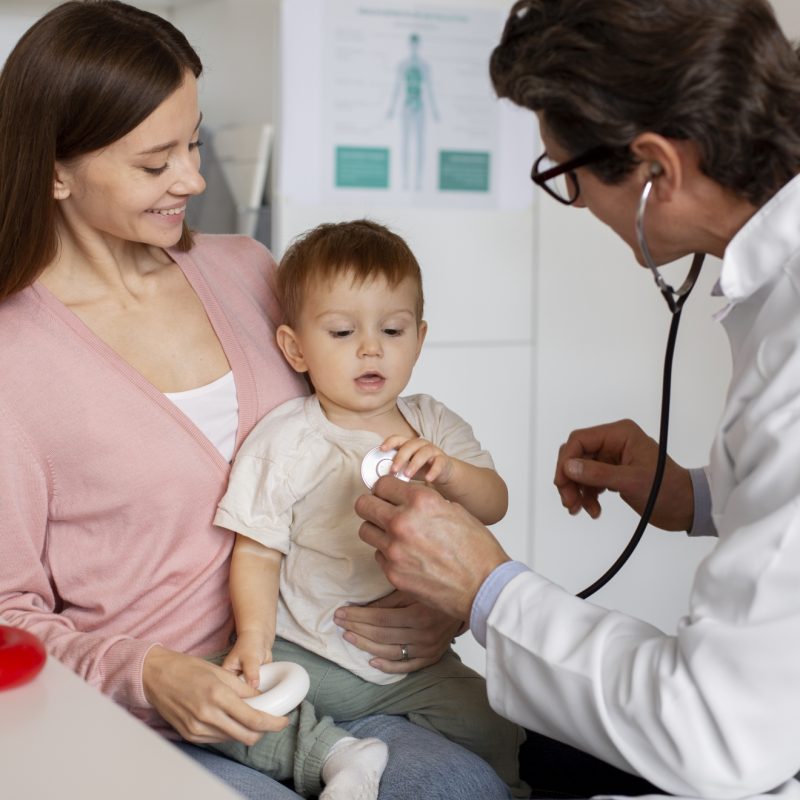 joven-madre-con-toddle-en-el-pediatra-para-una-consulta