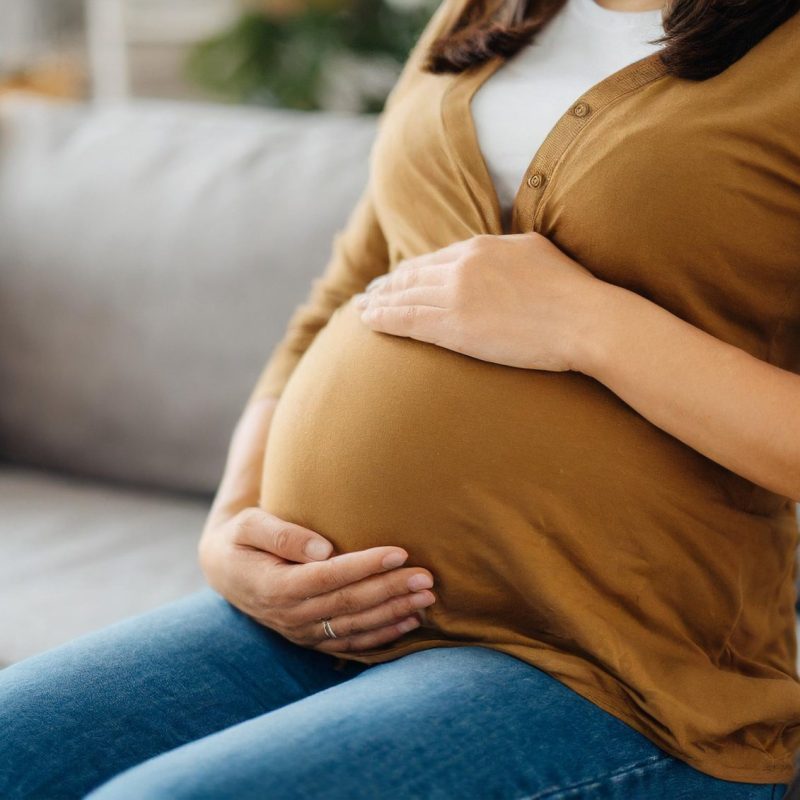 obstetricians-hand-tenderly-touches-pregnant-belly-home-visit-symbolizing-maternal-health-c.jpg